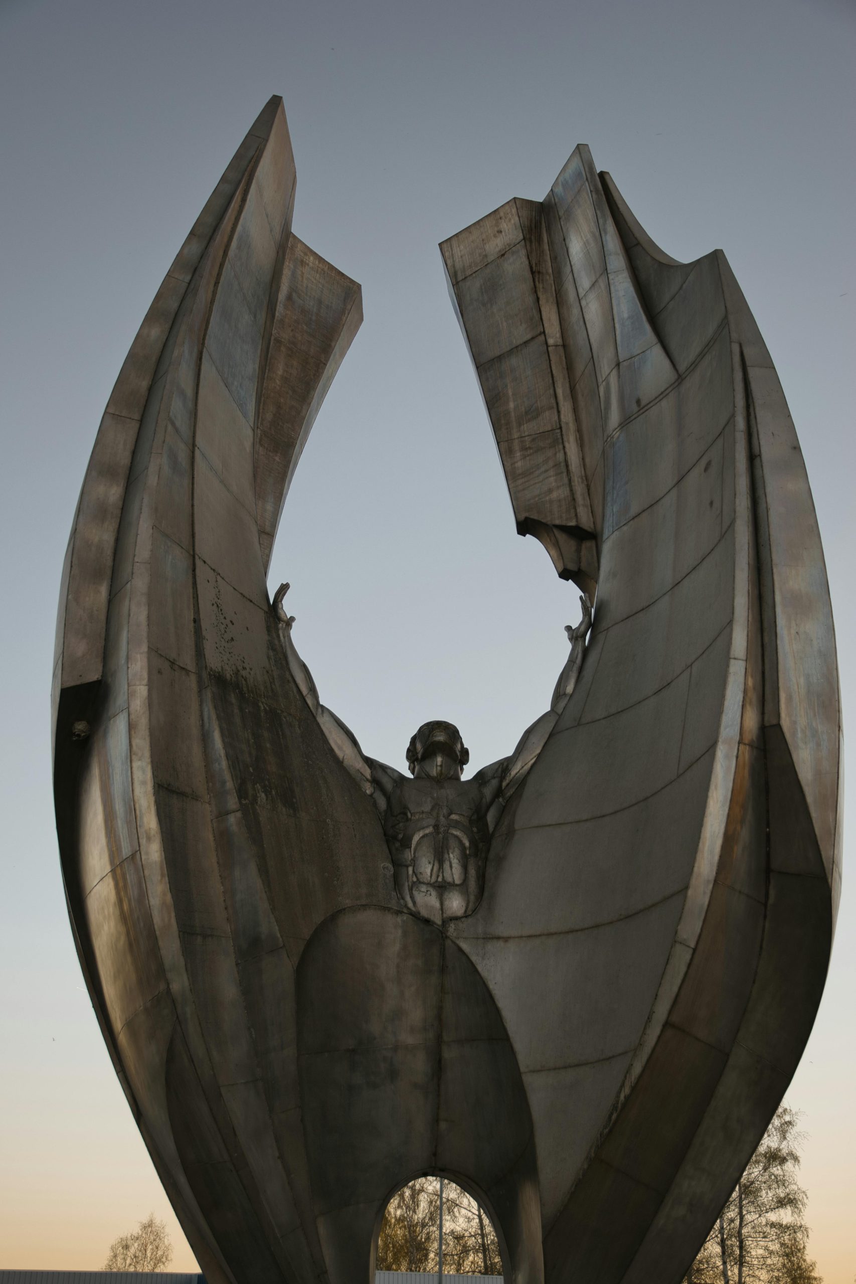 A dramatic monument depicting abstract shapes against a twilight sky, symbolizing strength and resilience.