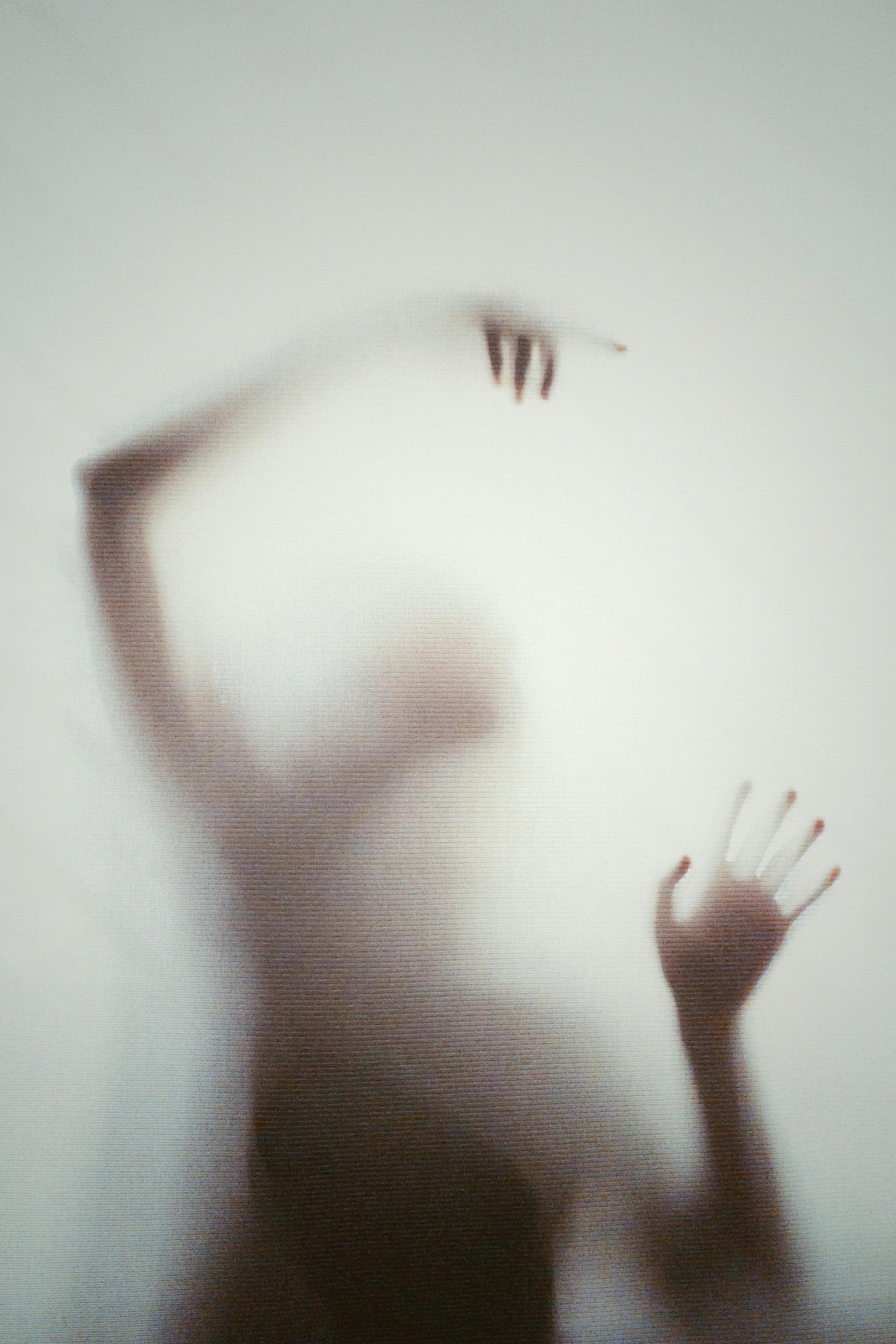 Ethereal silhouette of a person with blurred hands and arms, creating a mysterious and artistic ambiance.